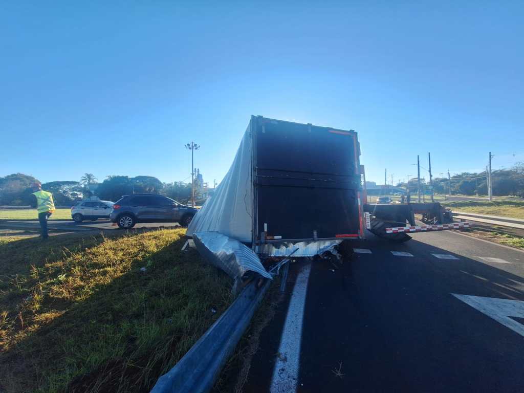 A carroceria de um caminhão-baú que transportava 7 toneladas de papel sulfite tombou na alça de acesso do km 228 da Rodovia Washington Luís (SP-310), em São Carlos