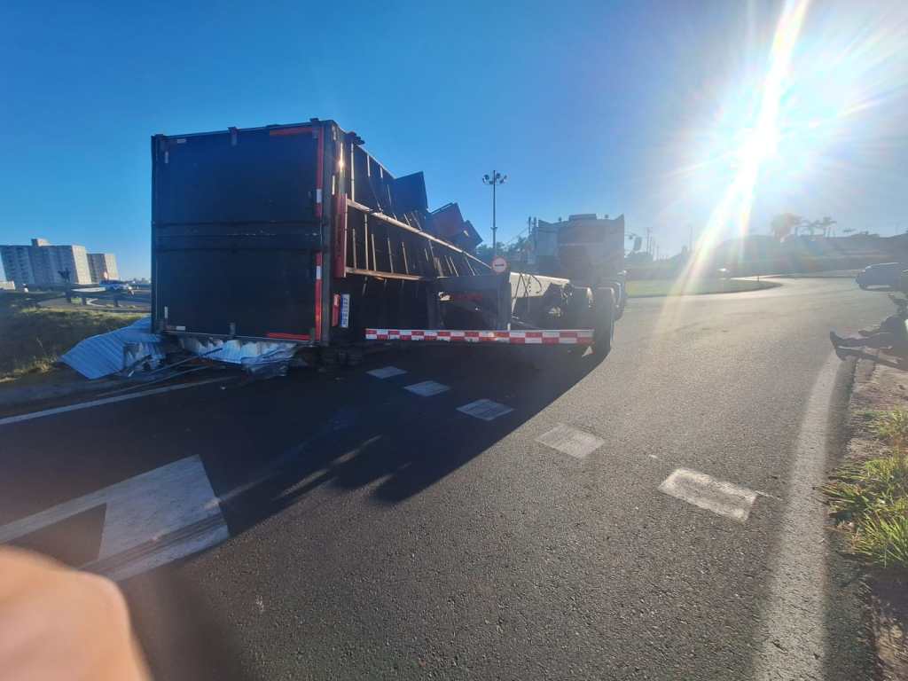 A carroceria de um caminhão-baú que transportava 7 toneladas de papel sulfite tombou na alça de acesso do km 228 da Rodovia Washington Luís (SP-310), em São Carlos