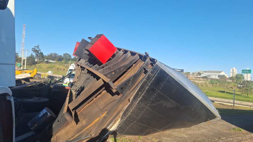 A carroceria de um caminhão-baú que transportava 7 toneladas de papel sulfite tombou na alça de acesso do km 228 da Rodovia Washington Luís (SP-310), em São Carlos